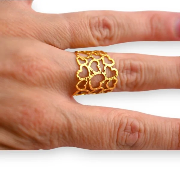 Anillo ancho de acero dorado con corazones