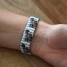 Pulsera elástica de eslabones estampados con gatitos puesta en la muñeca, vista desde arriba