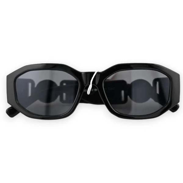 Schwarze rechteckige Brille mit goldenem Schmuck an den Bügeln