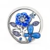 Broche magnético redondo calado color plata 5 cm con pequeña escena de jardín dentro, flor esmaltada azul real con ocho strass a