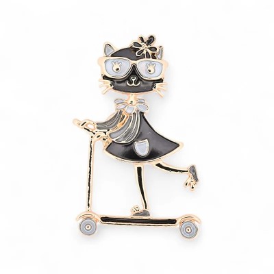 Broche figurativo gata antropomorfa negra de pie sobre un patinete oro rosa con dos ruedas blancas, vestido evasé en esmalte neg