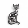 Vista frontale della spilla gatto floreale, gatto antracite seduto con occhiali wayfarer argento, fiocco bianco tra le orecchie 