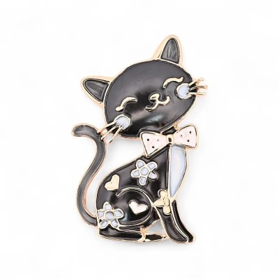 Vintage black cat brooch front view, glossy black seated kitty with sleeping eyes in rose gold lashes, pink polka dot bow tie, s