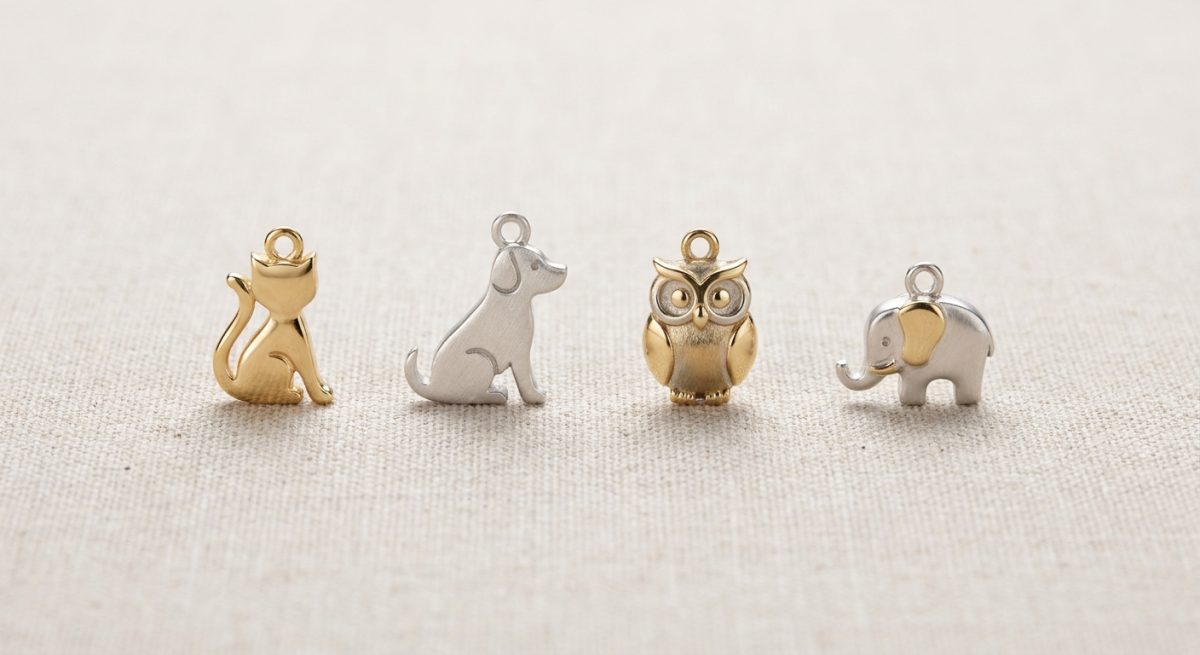 Quatre motifs animaliers en or et argent : chat, chien, hibou, éléphant