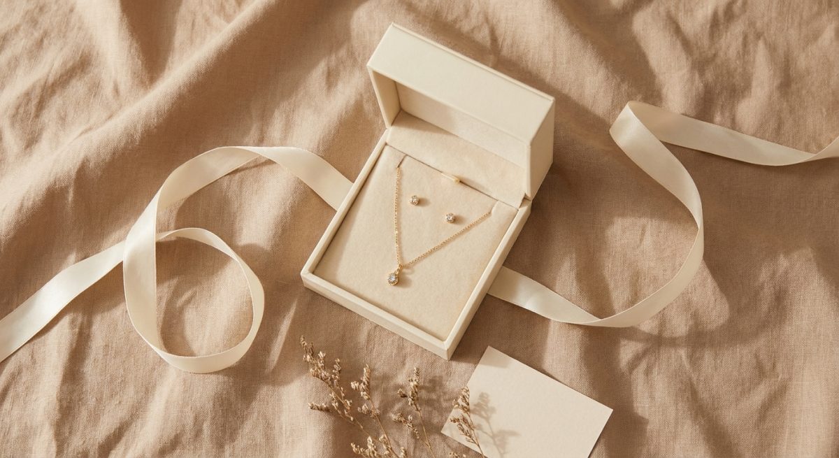 Coffret cadeau ouvert avec collier et boucles d'oreilles dorées pour un anniversaire de femme