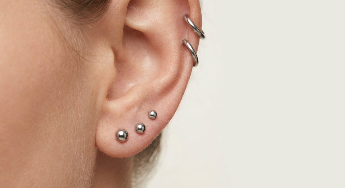 Verheiltes Ohr mit Ohrsteckern aus Edelstahl an Läppchen und Helix