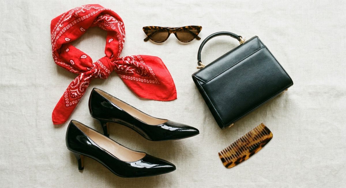 Accessoires rétro à plat : foulard carré rouge, escarpins, lunettes et petit sac structuré
